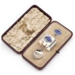 A GEORGE V SILVER AND ENAMEL CHRISTENING SPOON AND NAPKIN RING