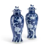 A PAIR OF CHINESE BLUE AND WHITE VASES AND COVERS
