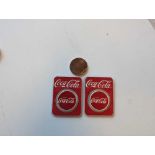 two silver Coca-Cola coins with copper American flag coin