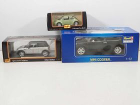A group of large scale diecast cars comprising a 1:12 scale Mini Cooper by REVELL, a 1:18 scale Mini