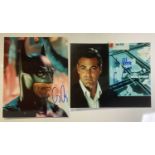 Two signed photographic stills of GEORGE CLOONEY (One as Batman) signed in blue pen, one