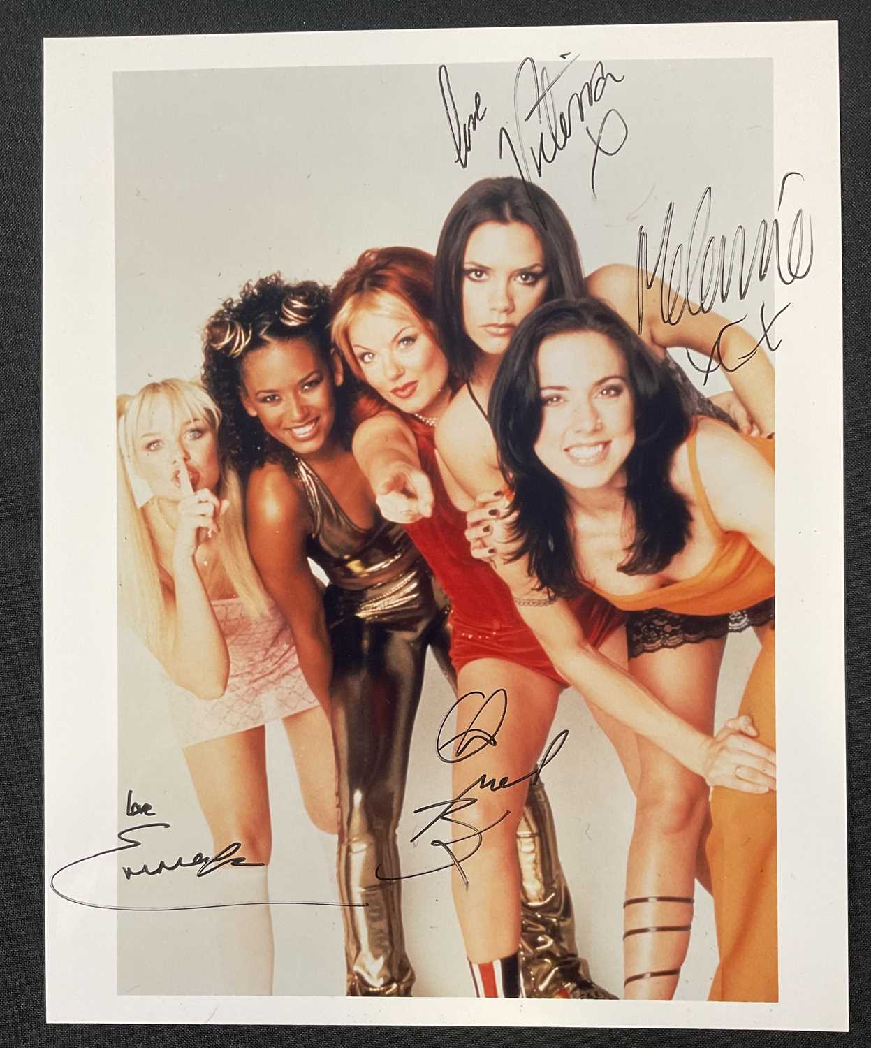 An 8" x 10" colour photograph of THE SPICE GIRLS signed by four members, EMMA BUNTON, VICTORIA