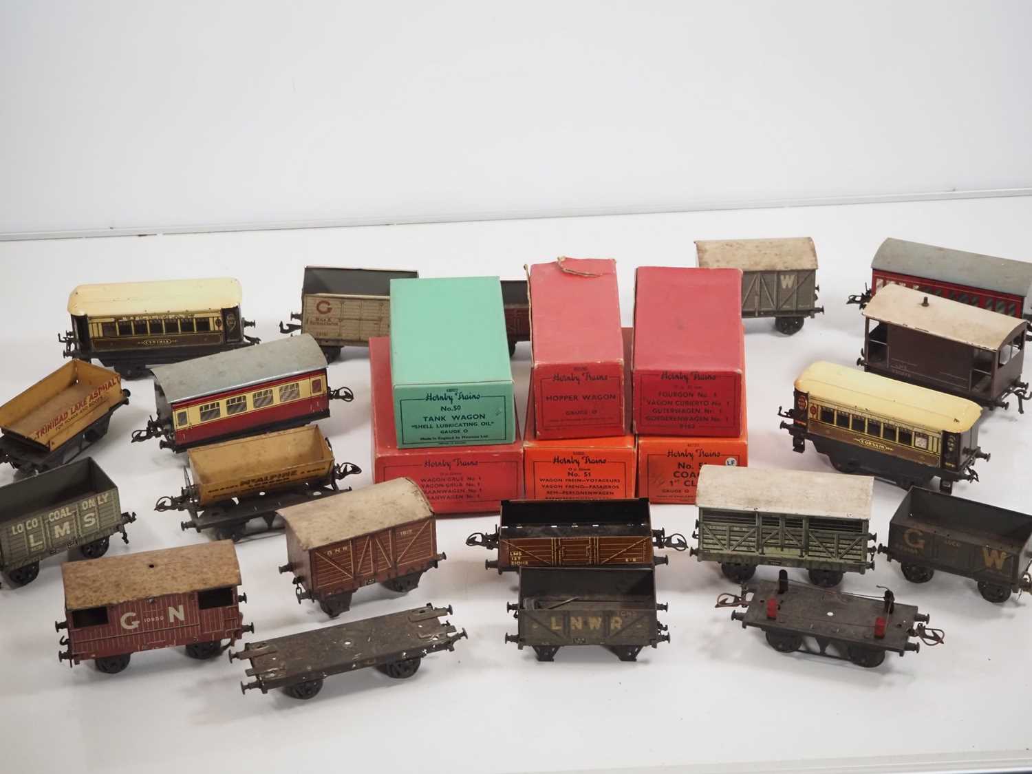 A large group of boxed and unboxed O gauge wagons and coaches by BASSETT-LOWKE, HORNBY and