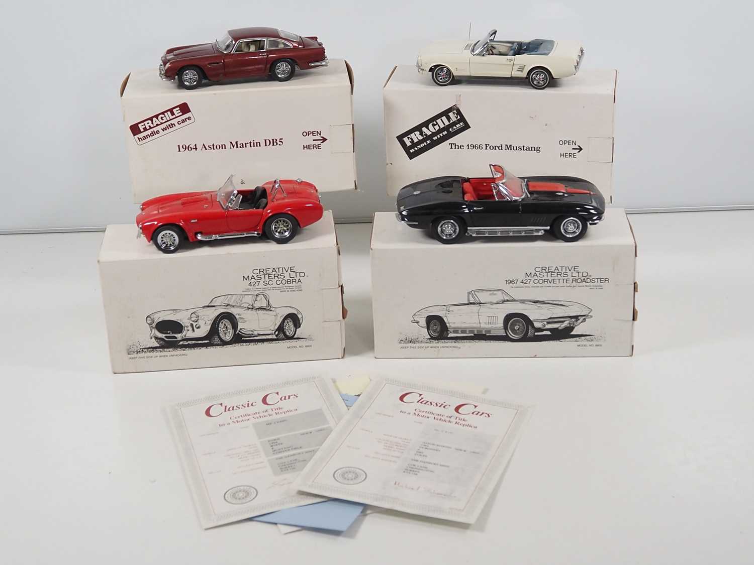 A group of mixed 1:24 scale diecast cars by DANBURY MINT and CREATIVE MASTERS to include a 1966 Ford