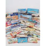 A large group of boxed unbuilt plastic kits in various scales of military planes and ships, mostly