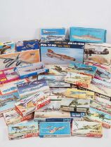 A large group of boxed unbuilt plastic kits in various scales of military planes and ships, mostly