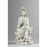 Le Boddhisattva Kwan yin assis à l'européenne un pied reposant sur une végétation aquatique, vêtu de
