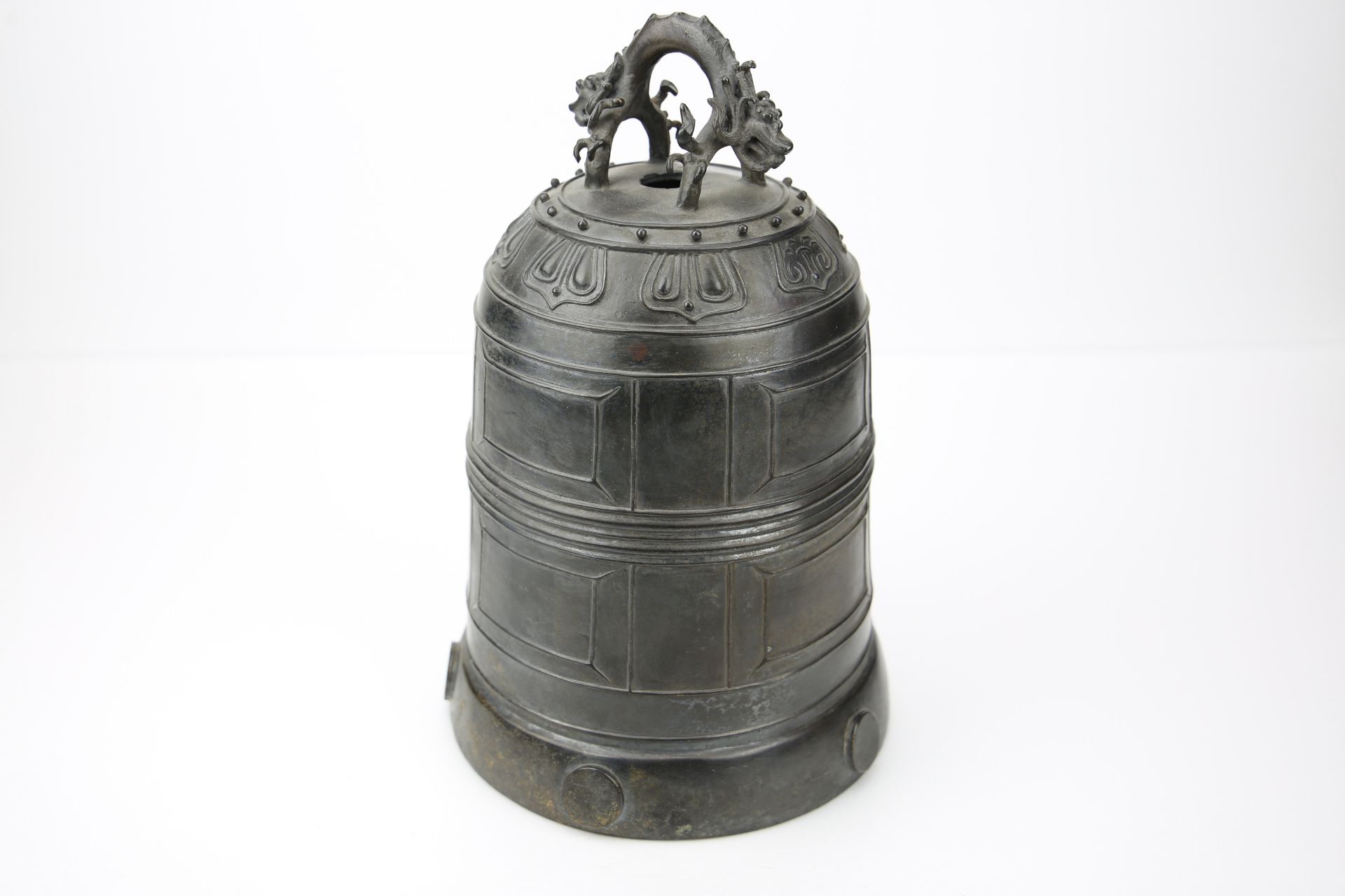 Cloche de temple moulée sur la paroi de motifs géométriques et d'une frise lotiforme surmontée d'