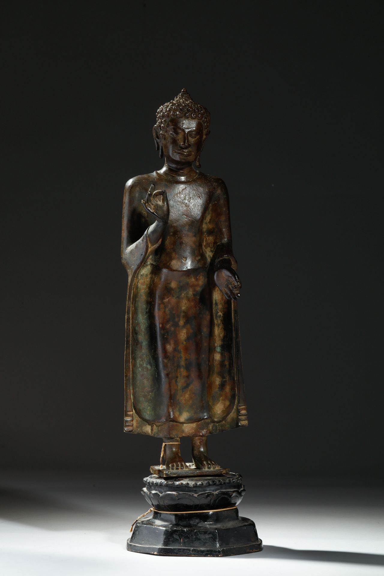 Buddha debout en posture hiératique, sur une base lotiforme , vêtu d’une robe monastique «