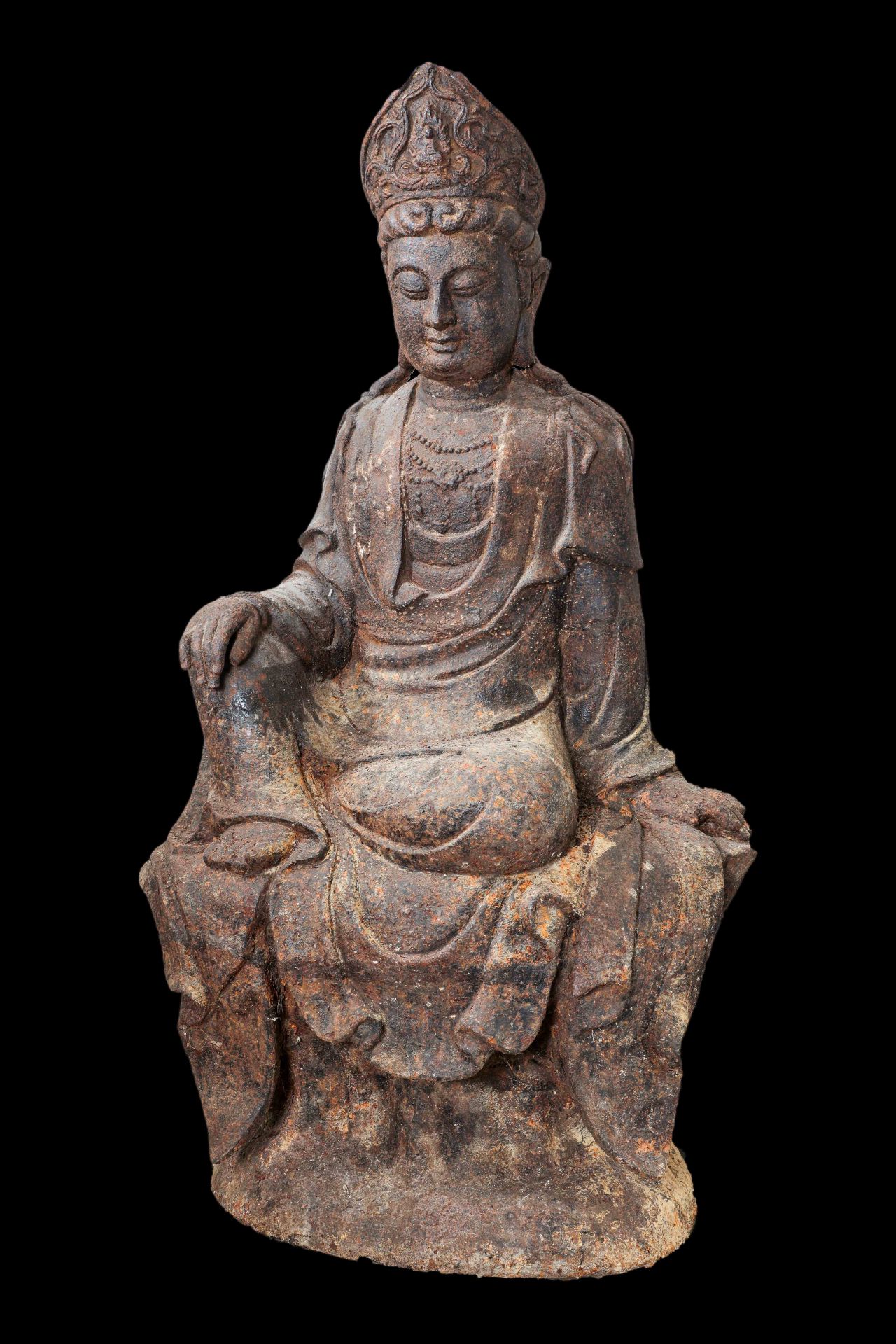 Kwan Yin, le Boddhisattva de la compassion assis en délassement sur une base rocailleuse, vêtu d’une