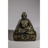 Portrait de Lama assis en méditation « Padma Asana »sur un coussin , les deux mains tenant le