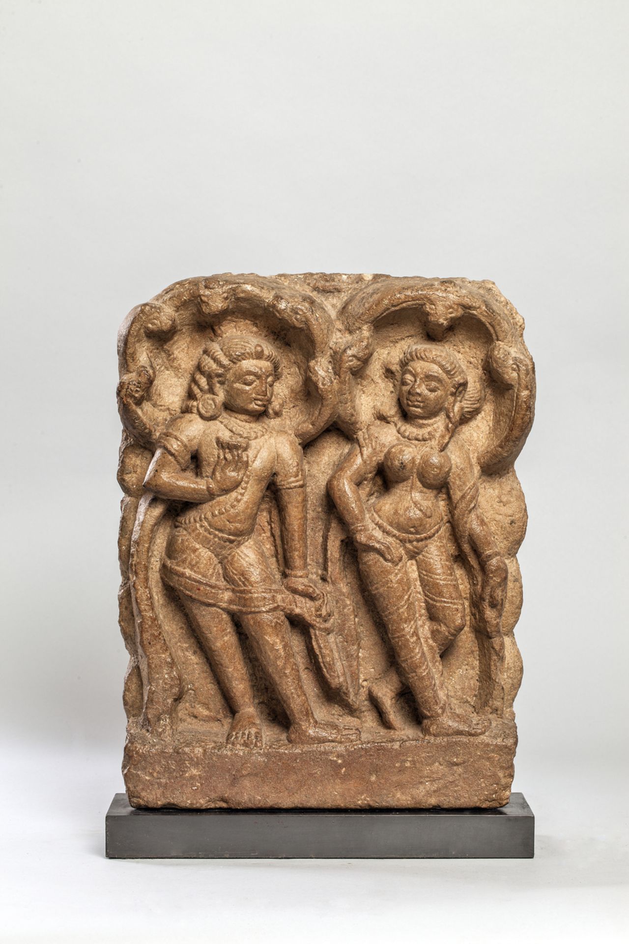 Haut relief de temple illustrant un couple Apsara Gandharva debout en tribanga abrités par des