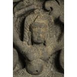 Haut relief de sanctuaire illustrant un gandharva dansant dans des rinceaux foisonnants Pierre