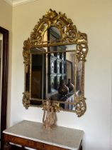 Grand miroir en bois doré à parcloses et fronton Décor d'aigles, de rinceaux feuillagés et fleuris