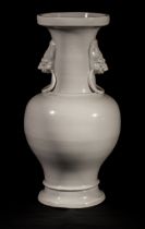 Vase balustre en porcelaine blanc de chine moulé au col de deux têtes de chimères tenant des anneaux