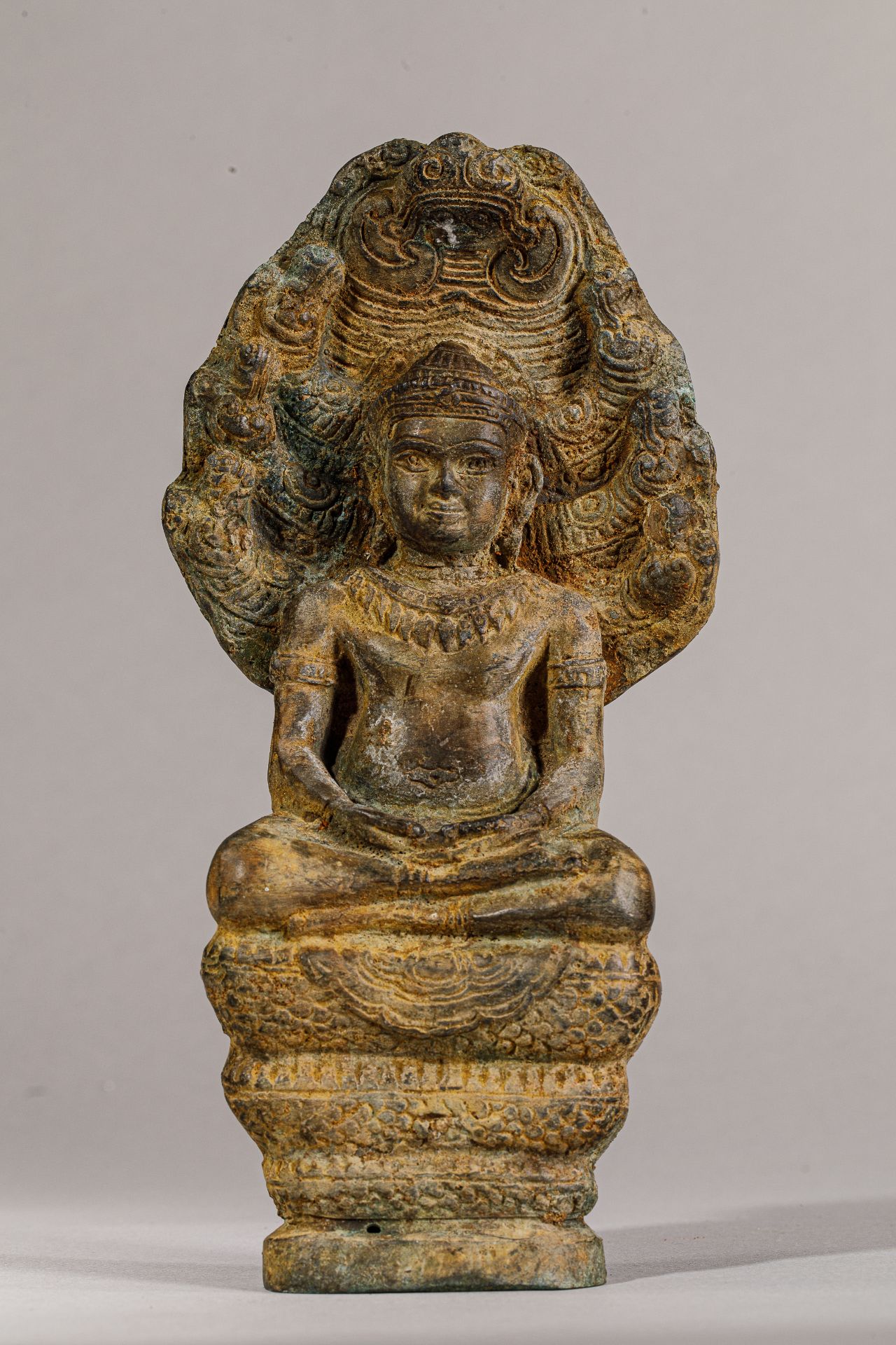 Buddha « Mucilinda » assis sur le corps du Naga abrité de son chaperon septa-céphale , pour le