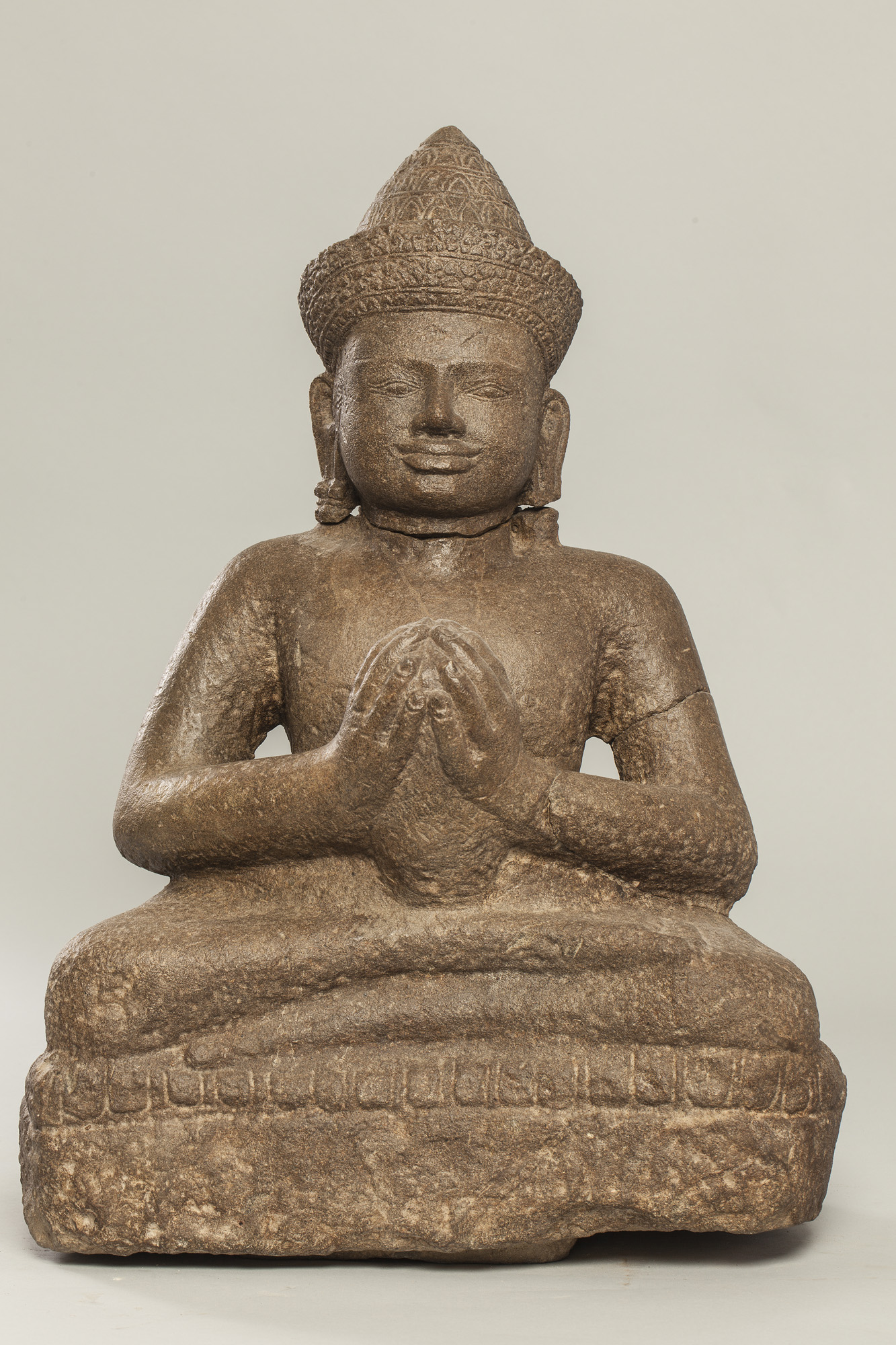 Vishnu assis en dianasana, les mains jointes tenant une offrande, coiffé d’un diadème filmant