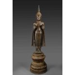 Important Buddha debout sur un haut tertre cylindrique , dans une posture hiératique, les deux mains