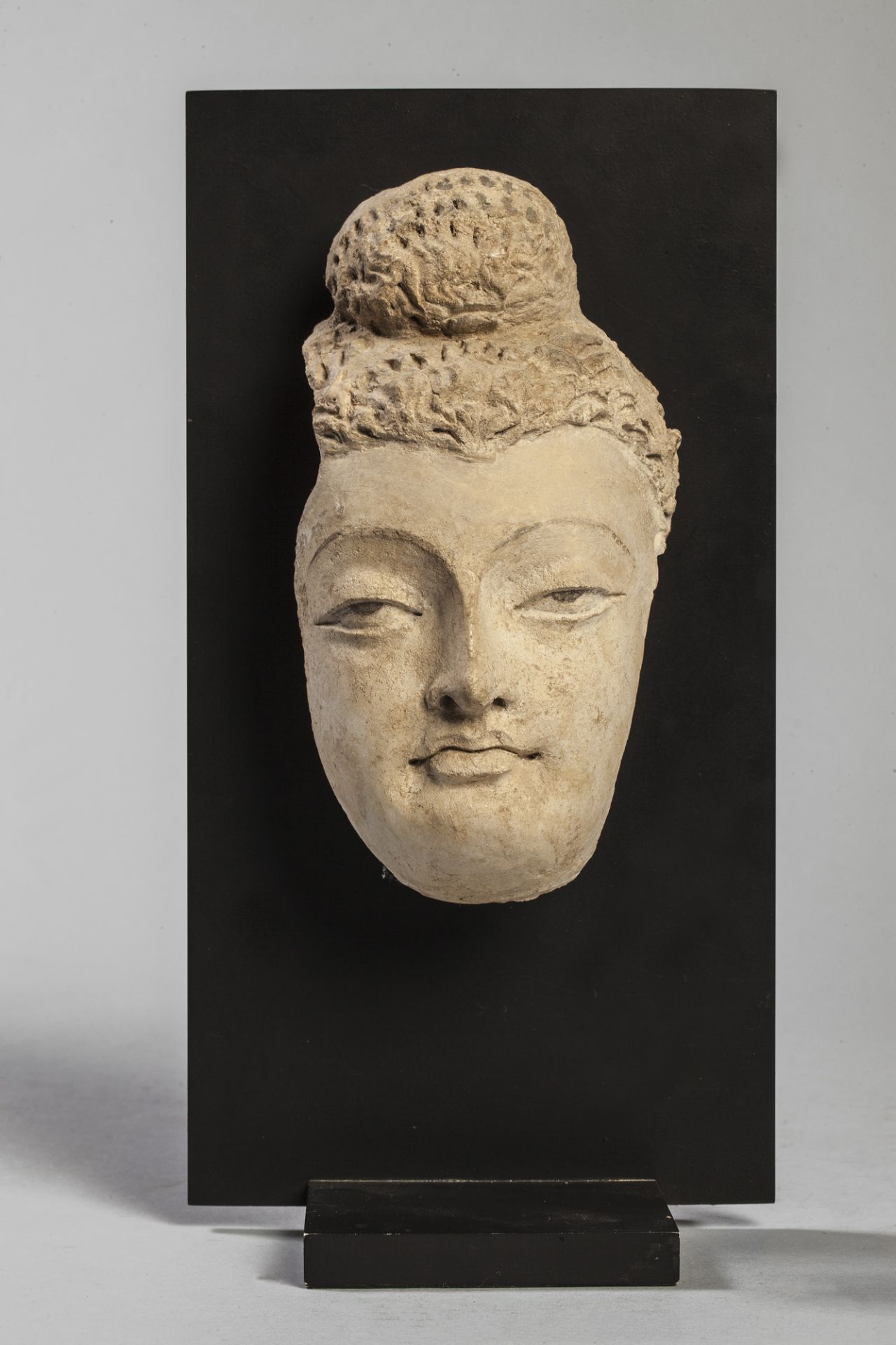 Partie faciale de Buddha à la beauté juvénile, la chevelure bouclée surmontée du chignon Ushnisha