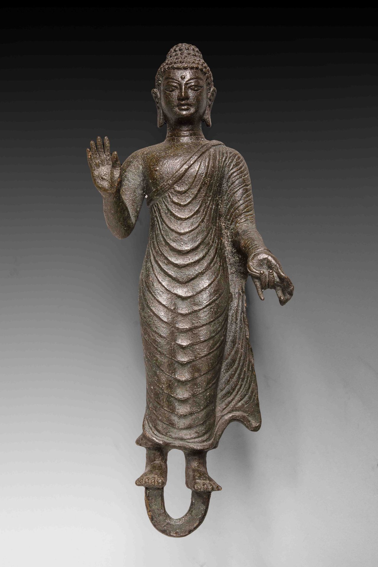 Buddha debout vêtu d’une robe monastique « uttarasangha » plissée moulant son corps juvénile, la