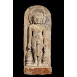 Stèle Tirthankara debout dans une posture hiératique vêtu d'un sampot noué, auréolé d'un nimbe les