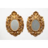Pair of large oval mirrors in carved and gilded wood, 19th century