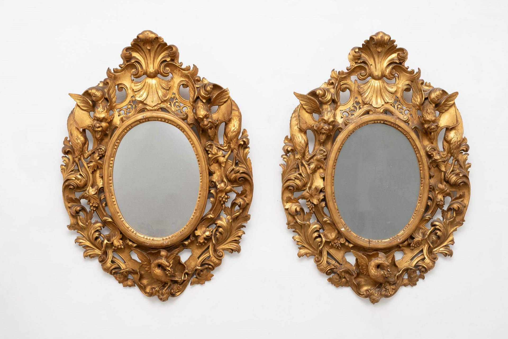 Pair of large oval mirrors in carved and gilded wood, 19th century