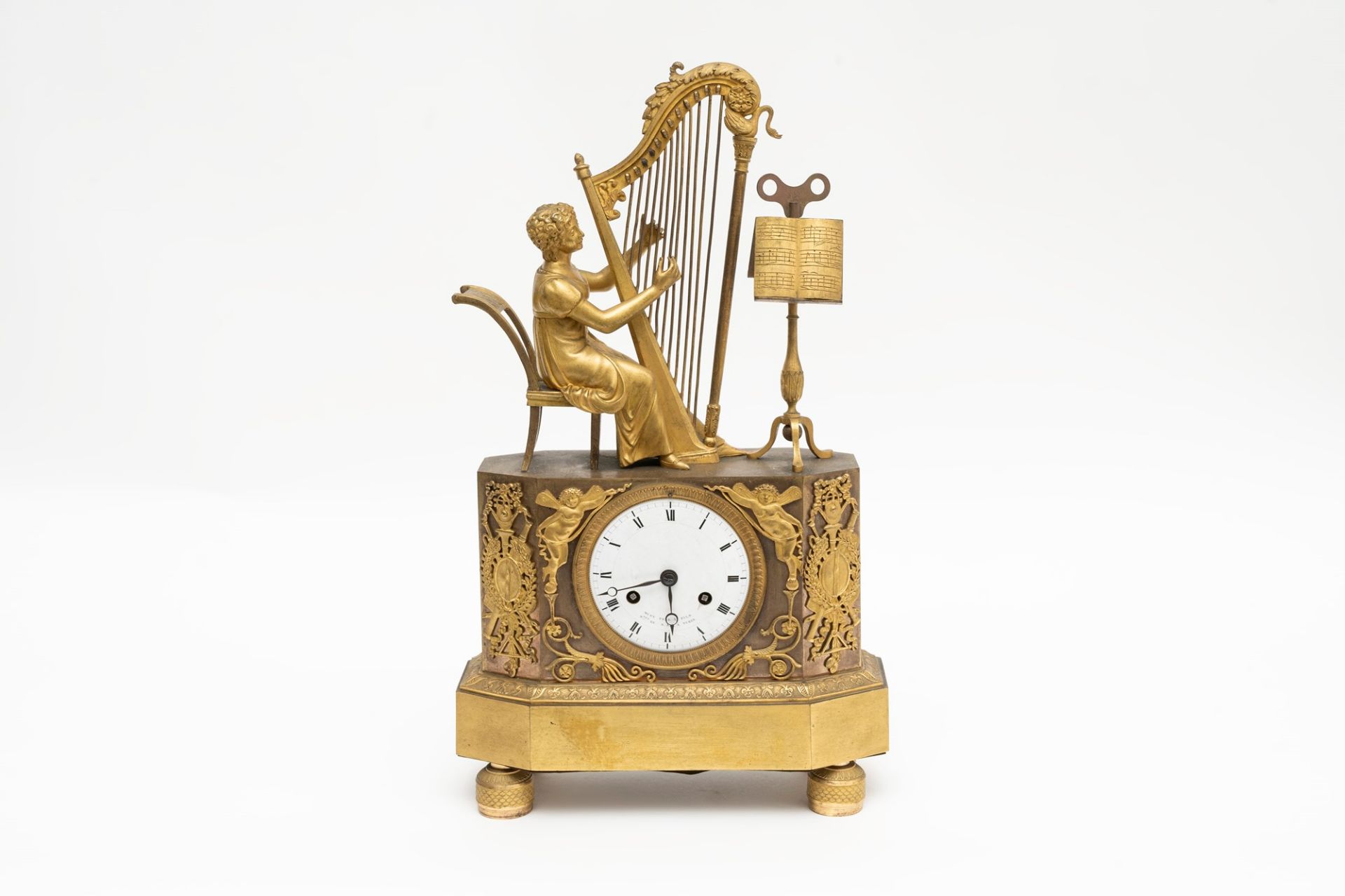 Empire clock in gilded bronze with girl playing the harp, early 19th century