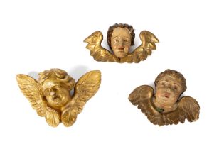 Three cherub heads in lacquered and gilded wood, 18th-19th centuries