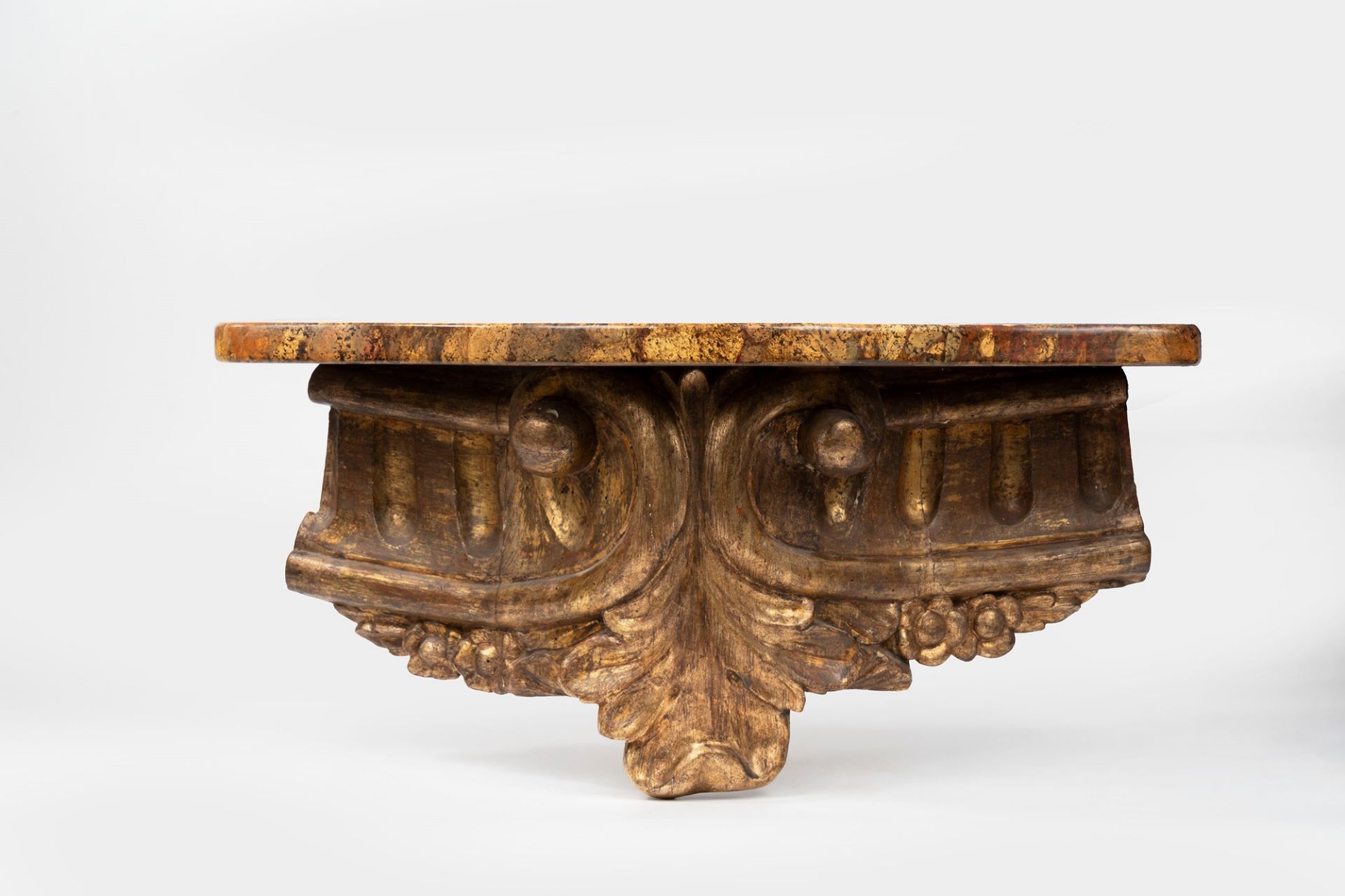 Carved and gilded wooden shelf with faux marble top