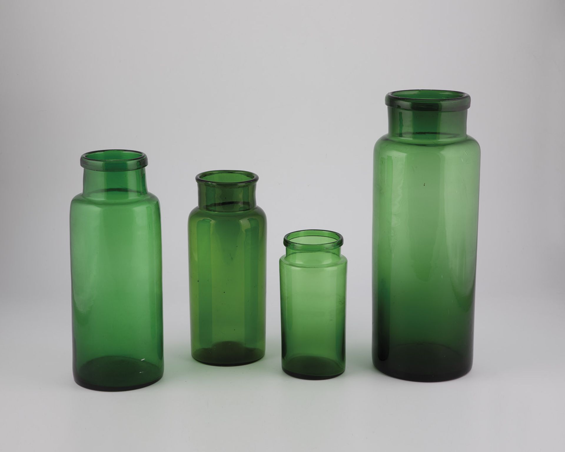 Four storage jars, 19th century, green glass. Cylindrical wall. The muzzle rim is folded outwards.