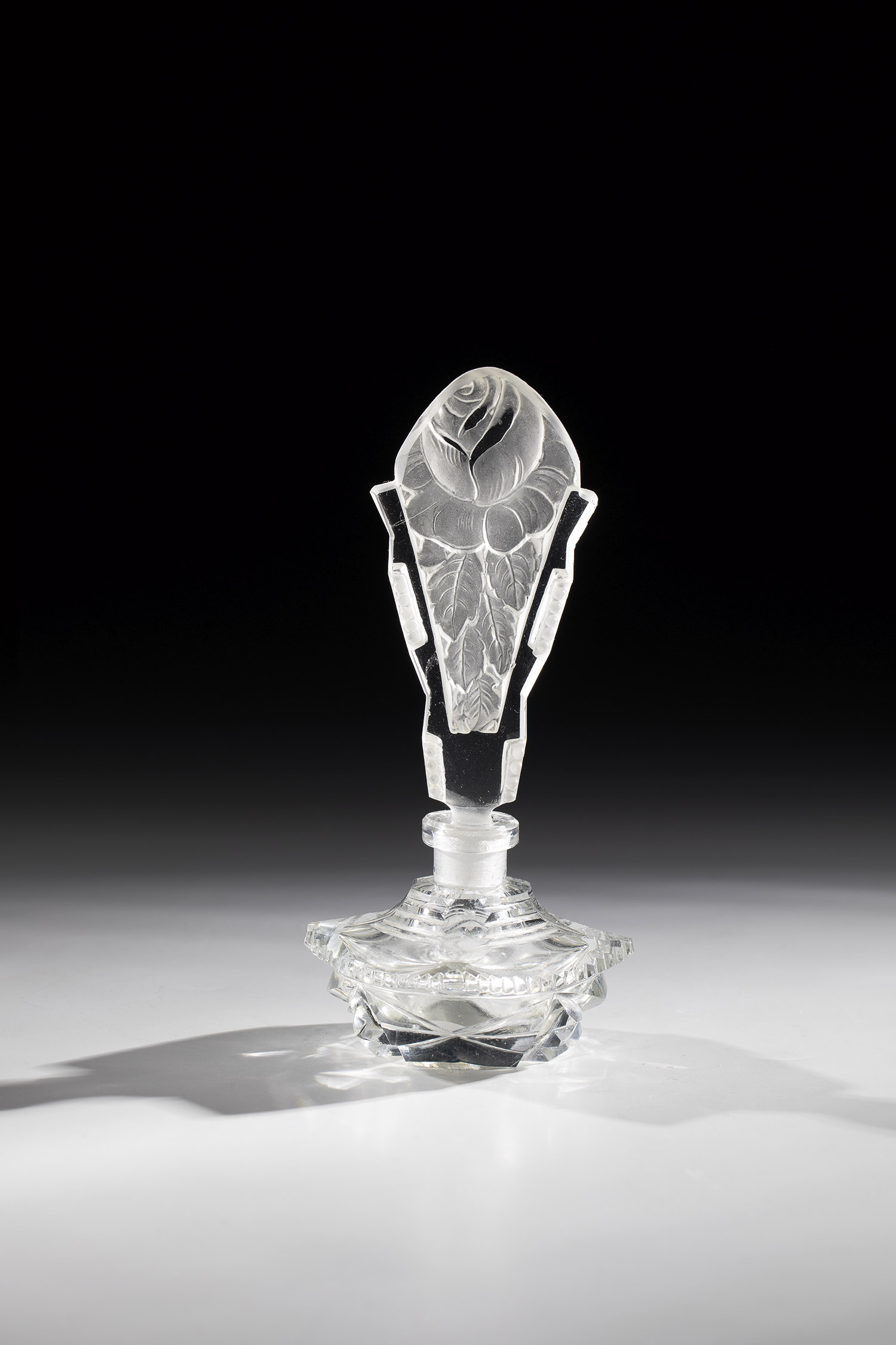 Perfume bottle Bohemia, ca. 1900 Colourless, geometrically decorated glass. Tall stopper made of
