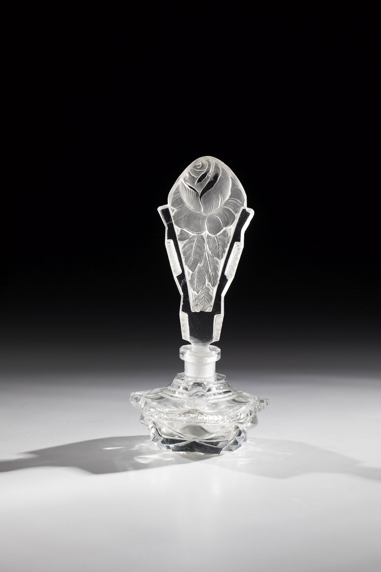 Perfume bottle Bohemia, ca. 1900 Colourless, geometrically decorated glass. Tall stopper made of