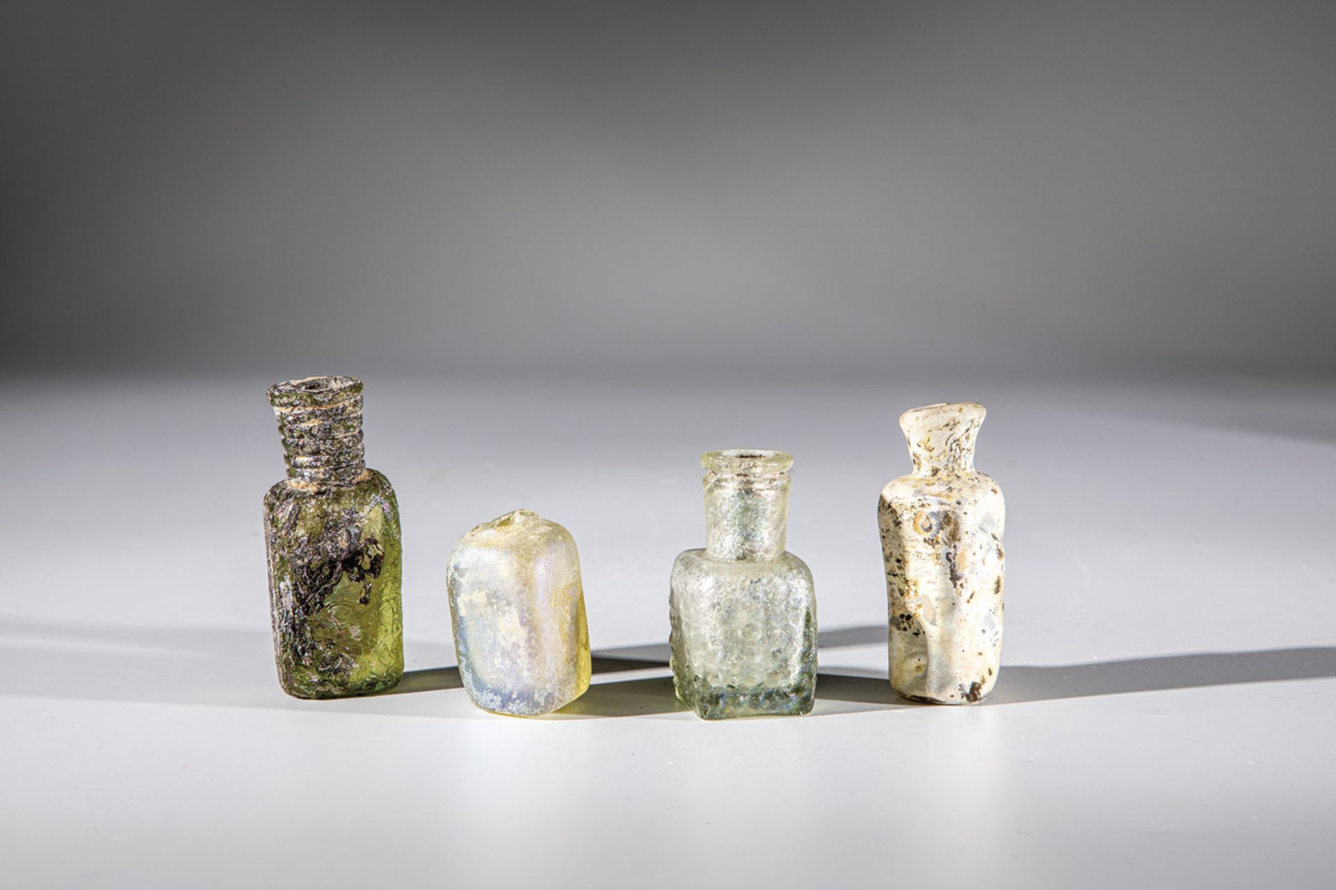 Four rectangular bottles Eastern Mediterranean, 1st-4th century AD. Greenish or yellow glass.