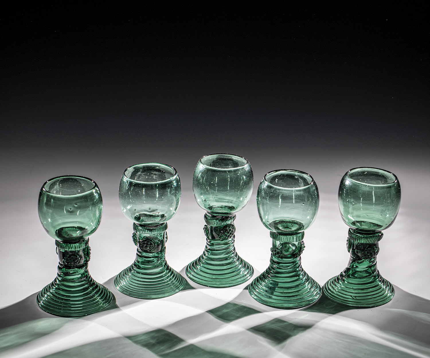 Set of five Romans Germany, 1st half of the 19th century Green glass with demolition. Woven foot.
