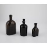 Three medicine bottles 19th century Brown glass, one bottle with stopper. H. 13 - 19 cm.