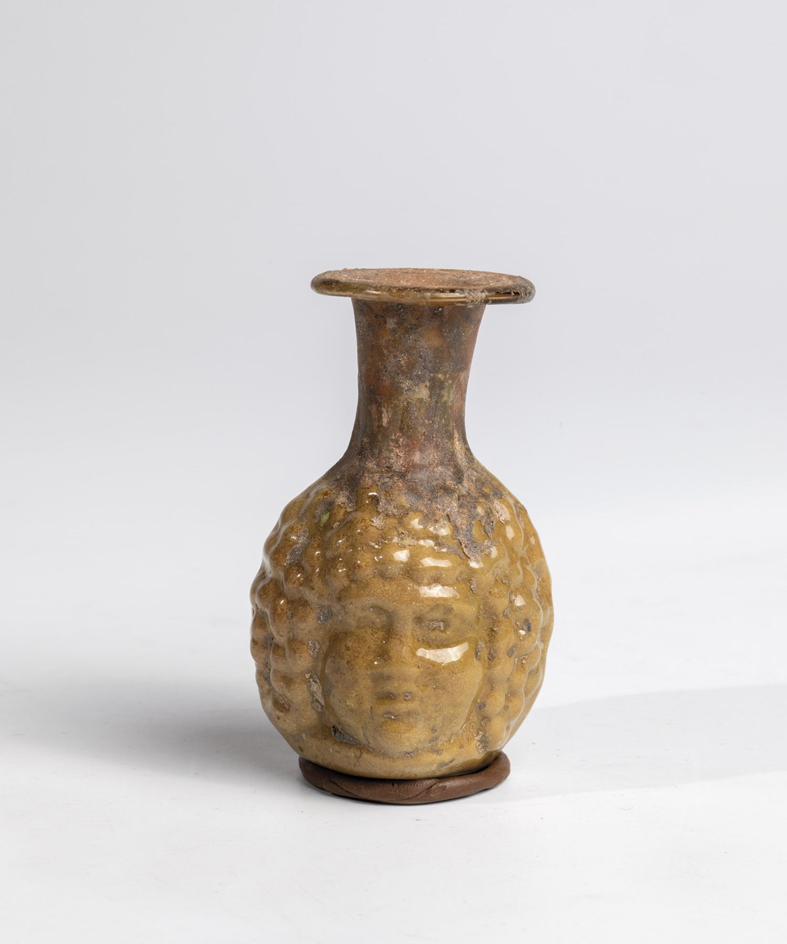 Small double-faced bottle Eastern Mediterranean, 1st-2nd century AD. Slightly brownish glass blown