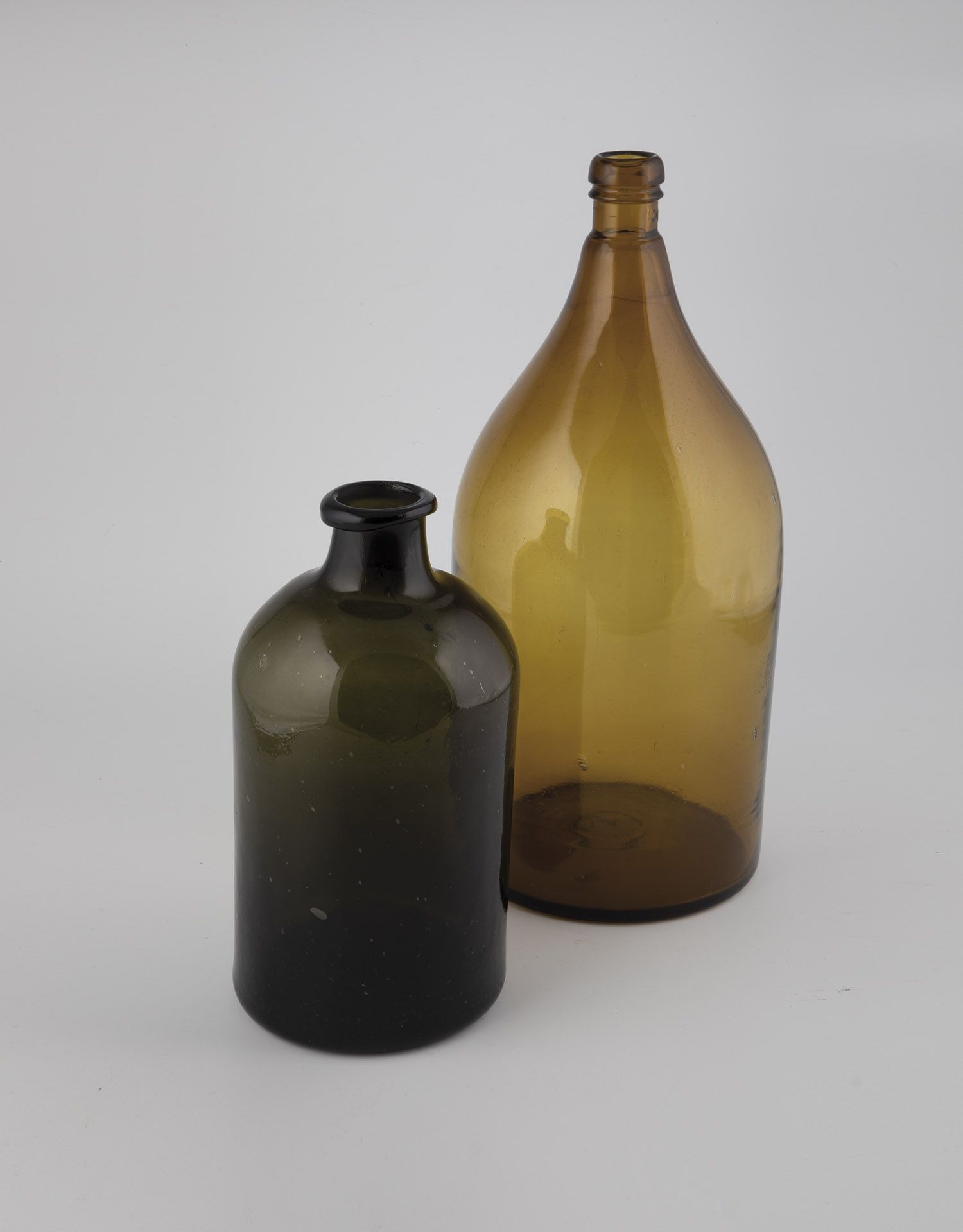 Two large bottles of 19th century brown and dark green glass, some with tear-off. H. 31.5-48 cm