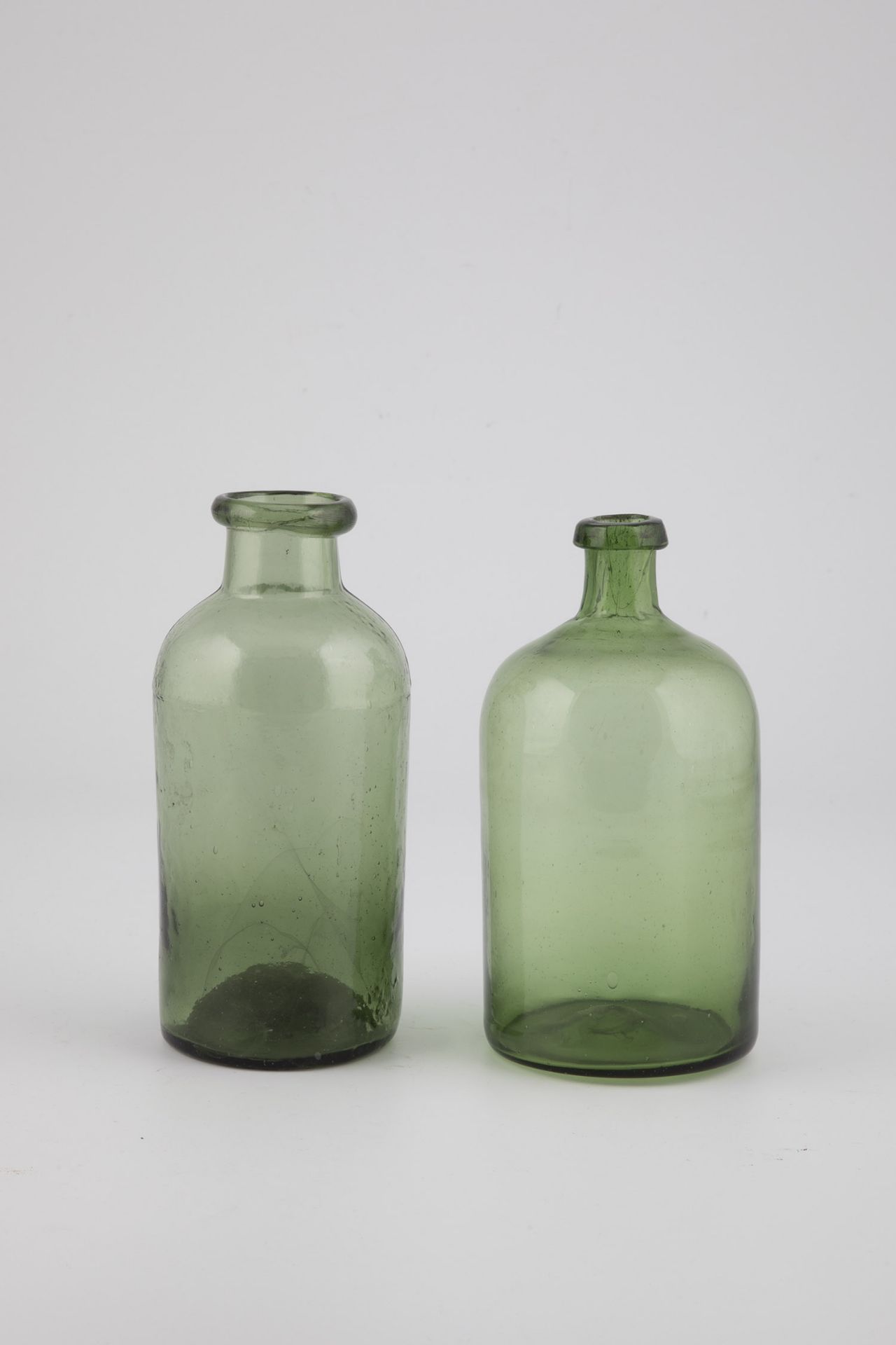 Two Bottles of Germany, 19th Century Light green glass with raised bottom and tear-off. H. 18.5 to