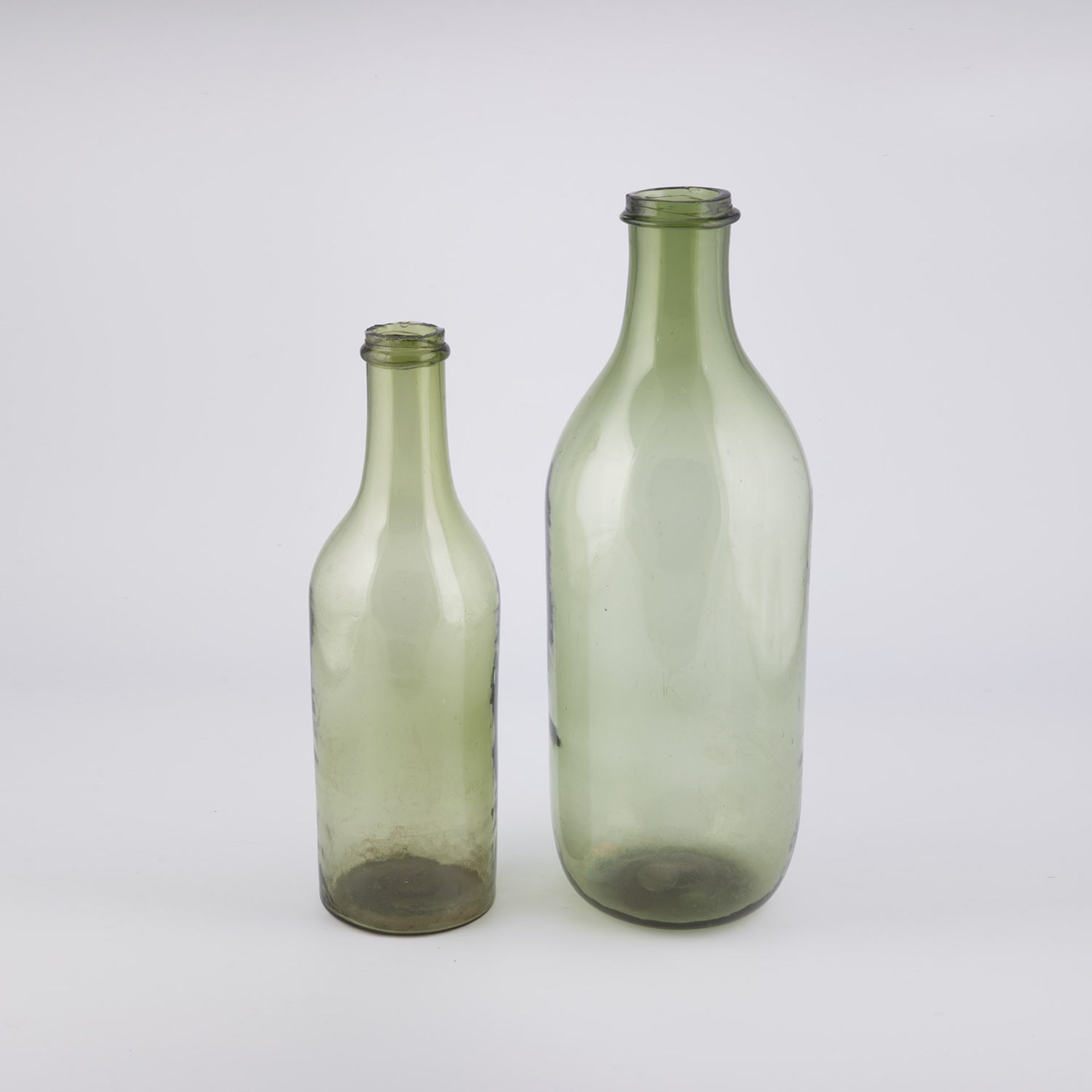 Two large storage bottles France, 19th century Transparent, strongly greenish glass with a flat