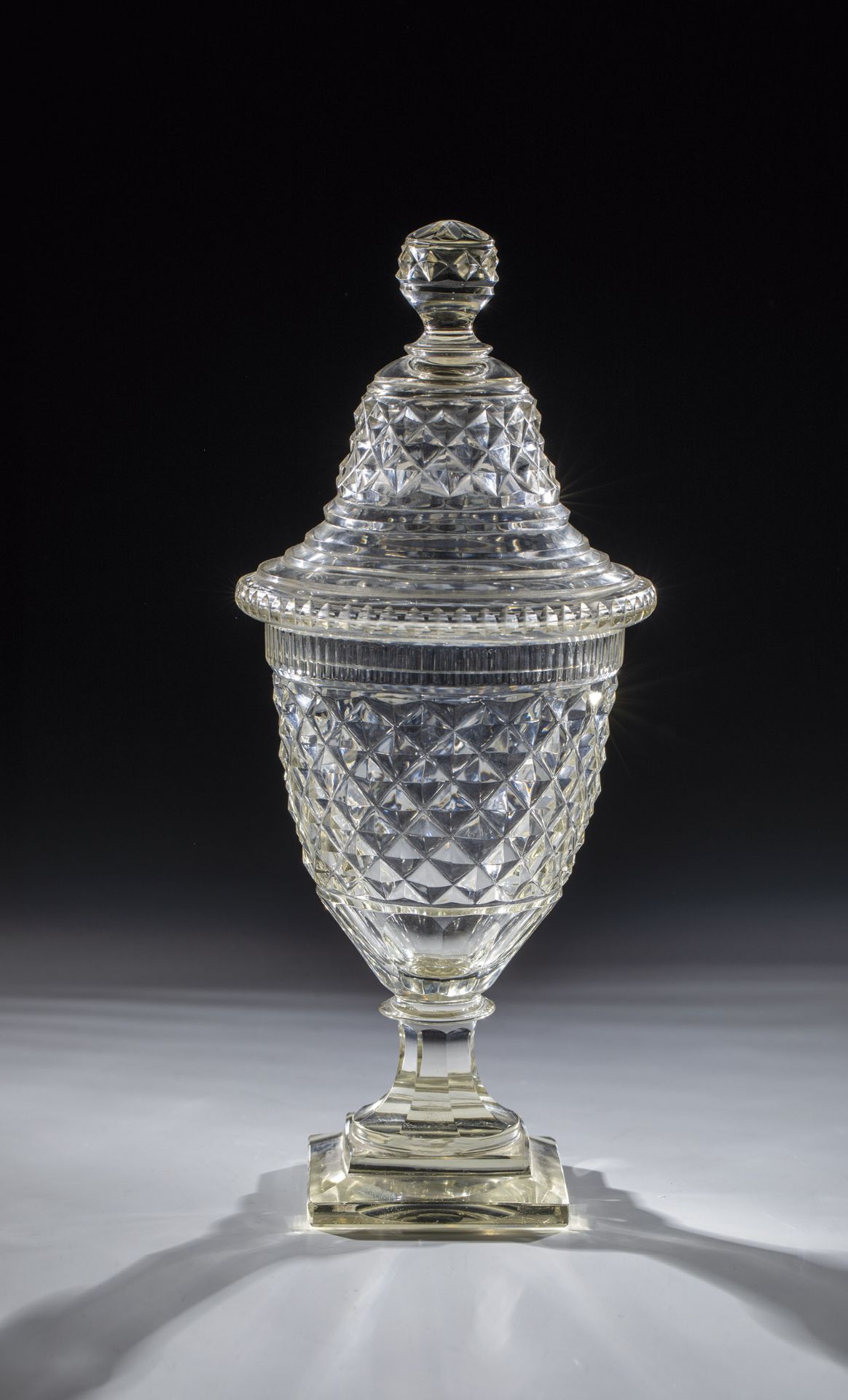 Lidded goblet A. 19th century Colourless glass. Stepped, square plinth merging into peeled shaft