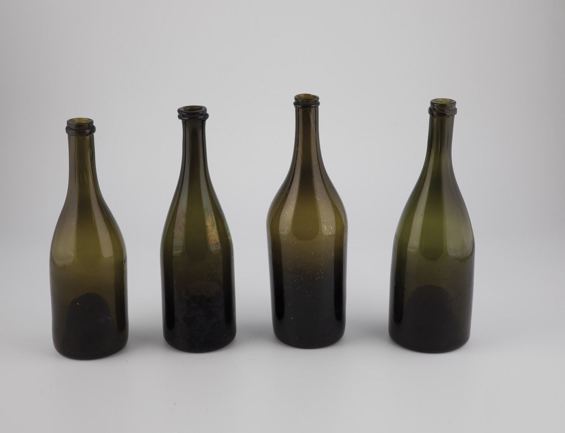 Four wine bottles France or Belgium, 1780-1800 Olive glass with tear-off and raised bottom. H. 28.