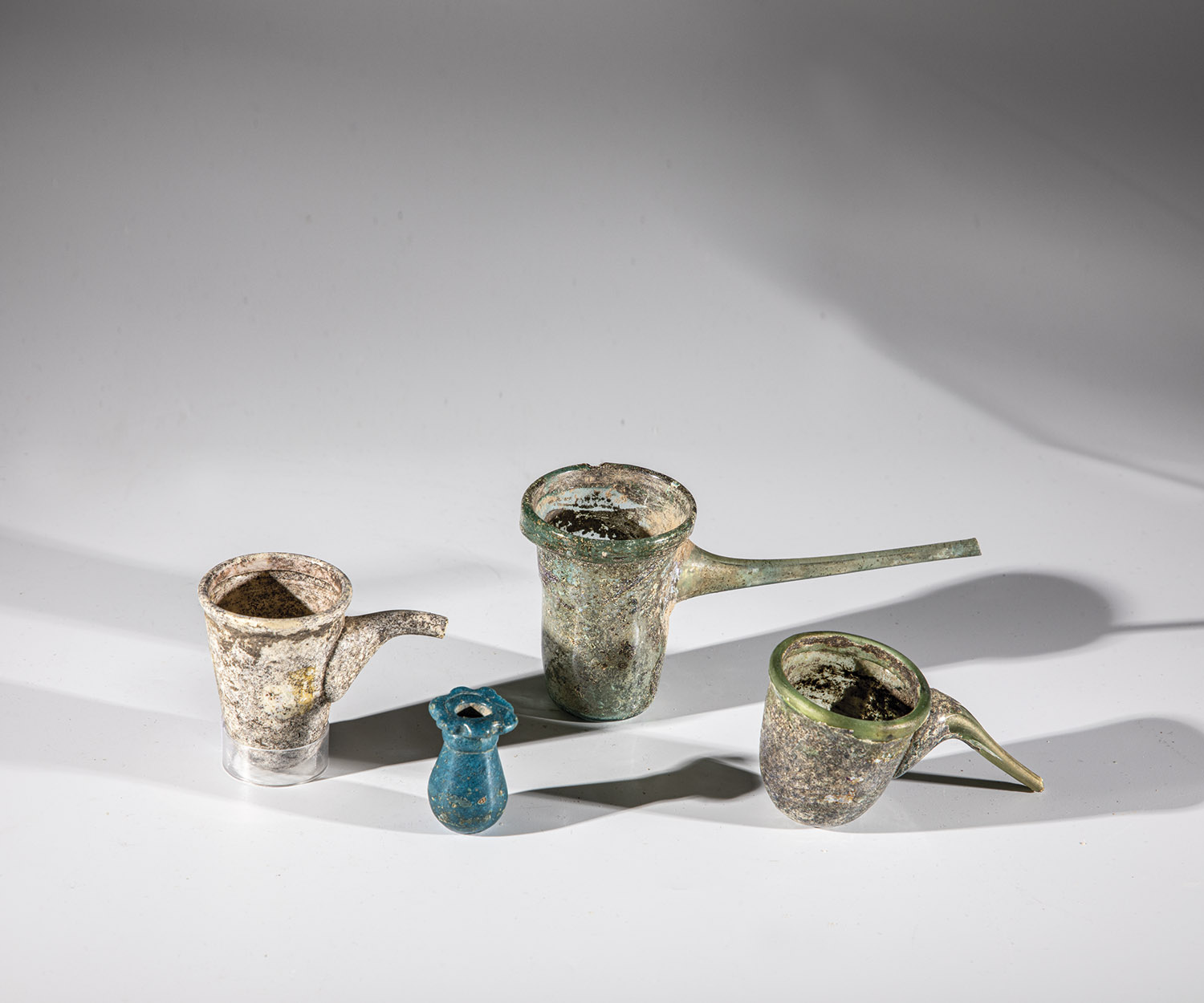 Three suction vessels and a small bottle Middle East, presumably Syria, 2nd-3rd century AD. Greenish