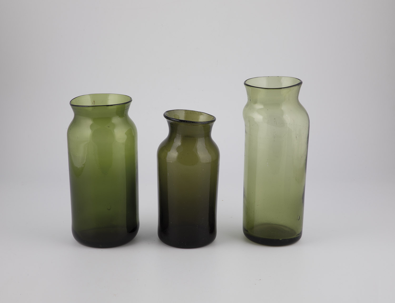 Three storage vessels France, 19th century Olive-green glass with tear-off, partly raised bottom.