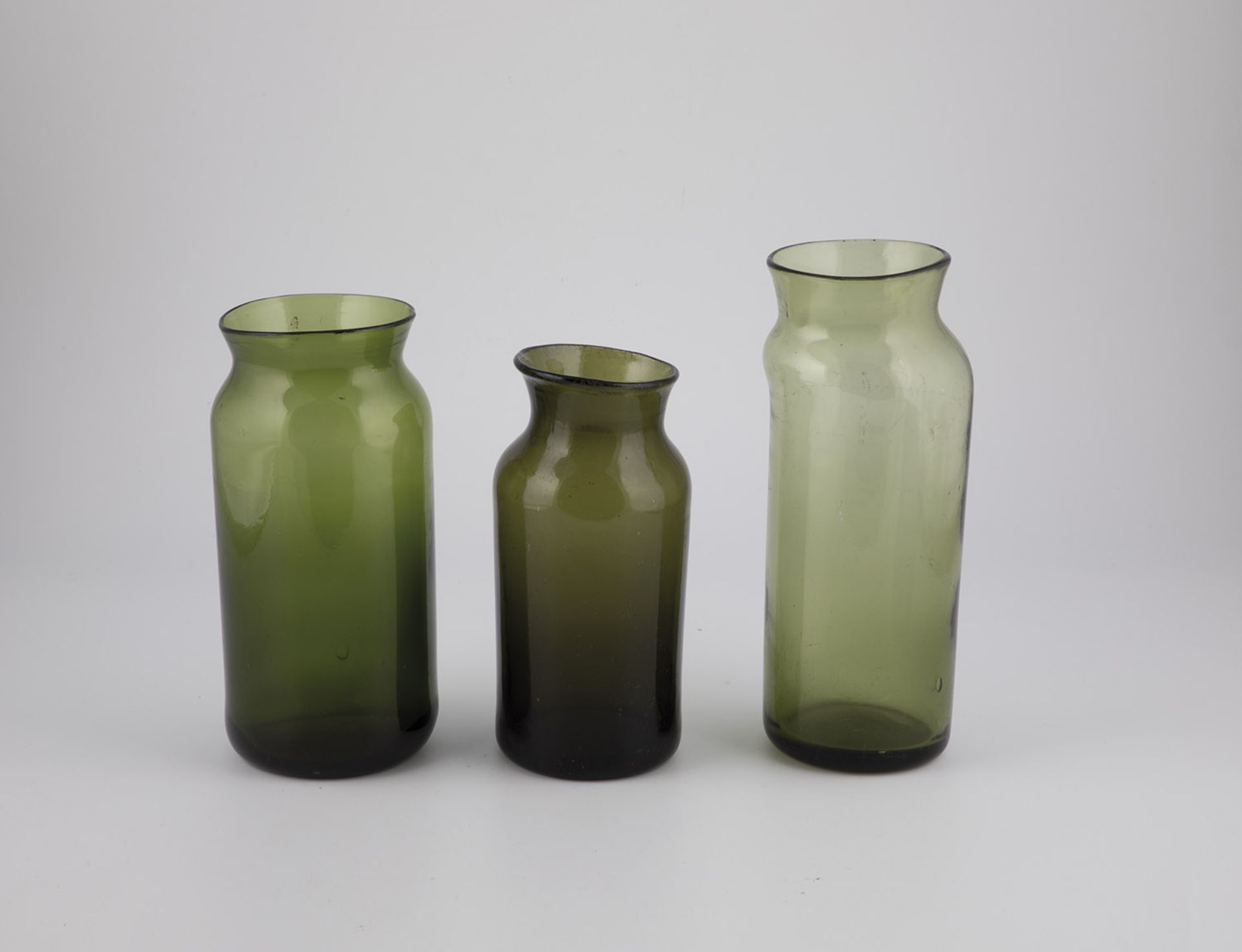 Three storage vessels France, 19th century Olive-green glass with tear-off, partly raised bottom.