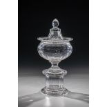 Urn-shaped lidded goblet England, 19th century Colourless, richly faceted glass. Pedestal stand,
