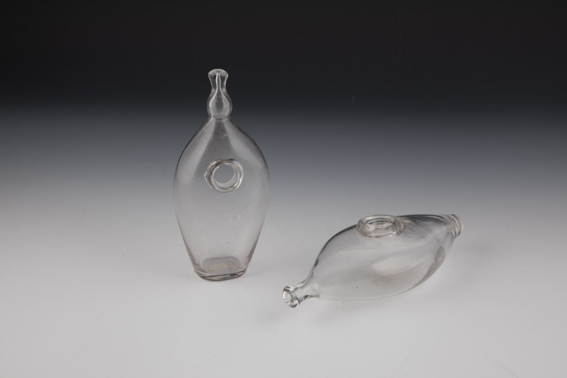 Two feeding bottles France, 20th century grey-tinted glass. 18.5 to 20.5 cm.