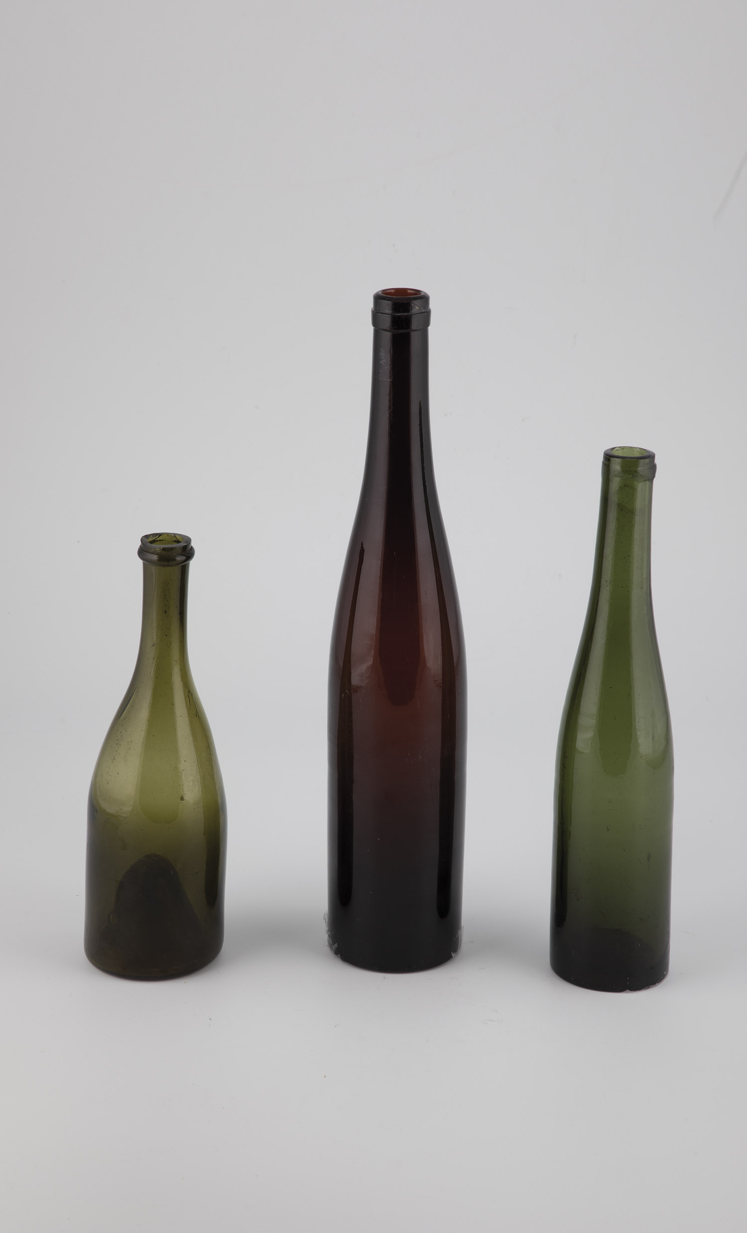 Three bottles (including Rhine wine) Rhineland, mid-19th century dark reddish-brown, green and