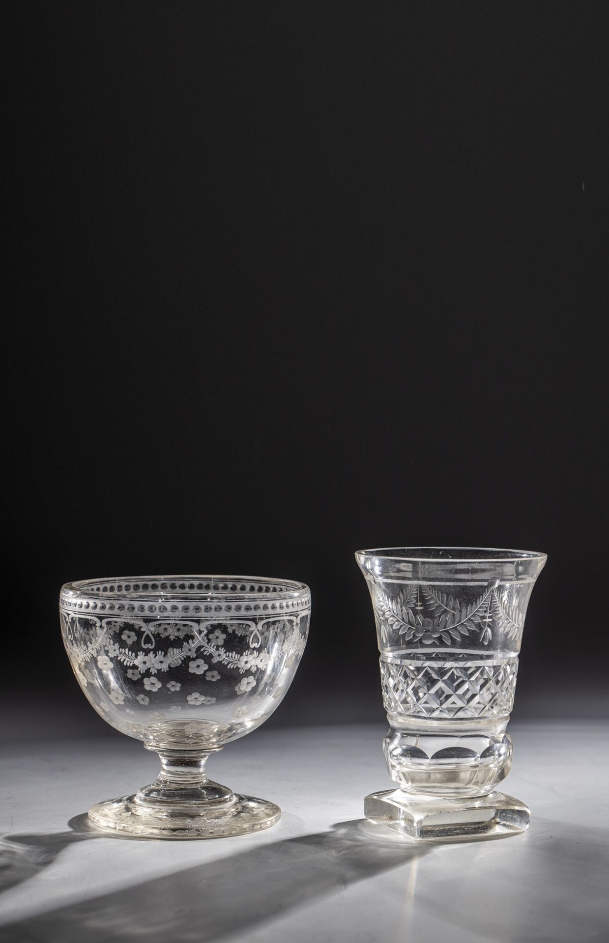 Foot bowl and foot cup 19th century Colourless glass, partly cut decorated. Cut garlands and