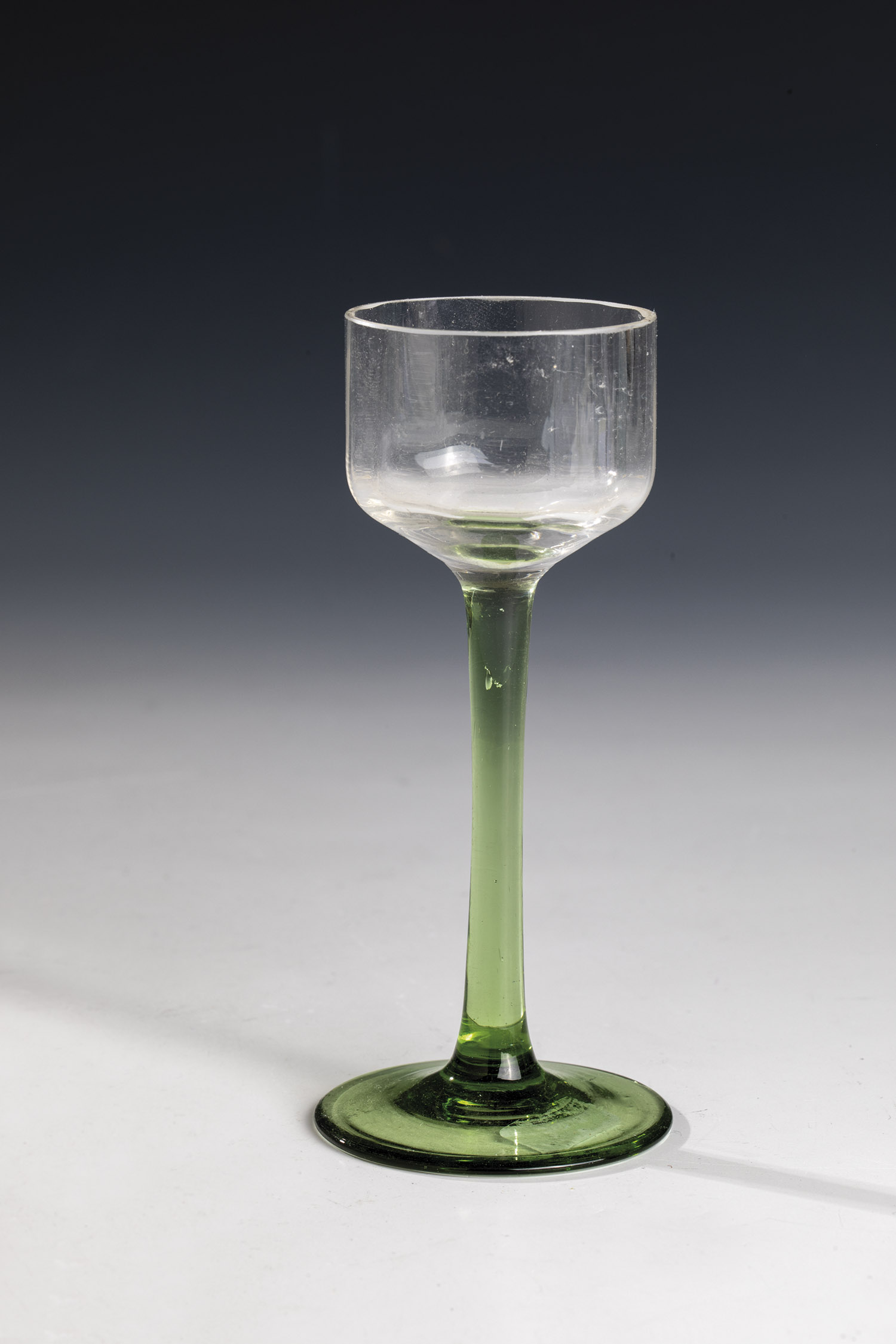 Stem glass Bohemia, circa 1910 Foot and shaft of green glass. Longitudinally optically blown